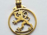 une photo d'un pendentif en or orné d'un lion