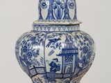 a blue and white vase with a bird on top of it