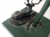 a statue of a deer sitting on top of a green base