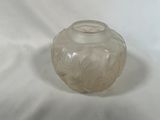 un vase en verre posé sur une surface blanche