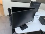 un écran d'ordinateur posé sur un bureau, à côté d'une imprimante