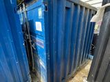 une benne bleue posée au milieu d'une cour