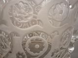 a glass vase with a design on it on a table