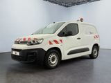 the white van is parked in a large room with a black floor