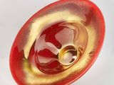a red and gold bowl with a gold ring inside of it