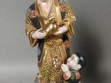 a figurine of a man holding a child