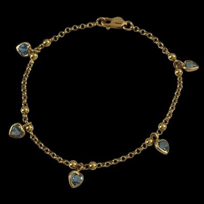 un bracelet en or orné de pierres bleues