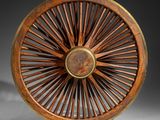 an antique wooden wheel with spokes on a white surface