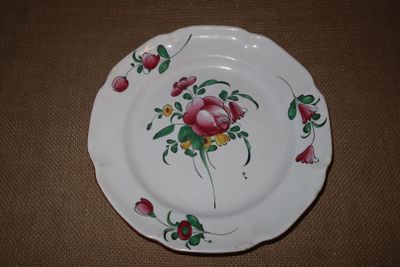une assiette blanche ornée de fleurs roses, posée sur une table