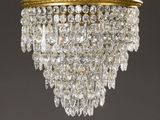 a gold plated chandelier with crystal drops hanging from the ceiling
