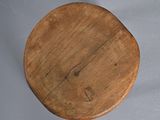 a wooden plate with a wooden handle on a table