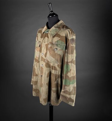 une veste militaire posée sur un mannequin, sur fond noir