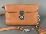 a close up of a brown purse with a chain around it