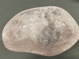 a pink rock sitting on a table next to a pair of scissors
