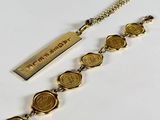 a close up of a gold bracelet with wax seals on it