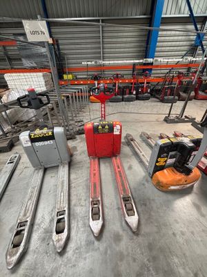 several skis are lined up in a warehouse with a fork lifter