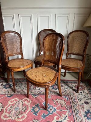three chairs and a table in a room with a rug on the floor