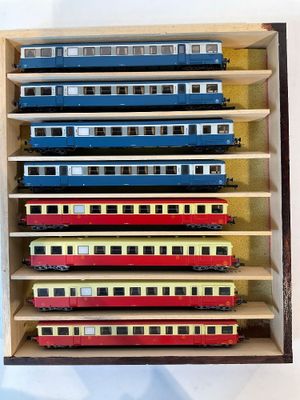 beaucoup de petits trains qui se trouvent dans une boîte en bois