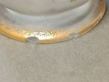 a white vase with a gold decoration on it
