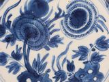 a blue and white plate with flowers and birds on it