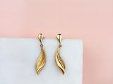 a pair of gold earrings on a marble block