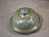 a close up of a ceramic covered dish on a table