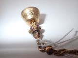 a gold bell with a chain around it on a table