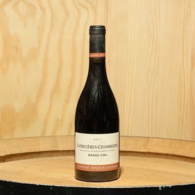 a bottle of wine sitting on top of a barrel