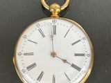 a gold pocket watch with roman numerals on the face