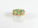 Gros plan sur une bague en or ornée d'émeraudes et de diamants