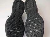 the soles of a pair of black shoes on a white surface