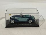 a toy car in a display case on a white surface
