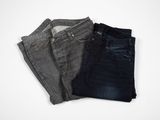 three pairs of jeans sitting on top of each other on a white surface