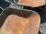 two wheelbarrows that are sitting on the ground