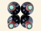 three bottles of wine are lined up on a white surface
