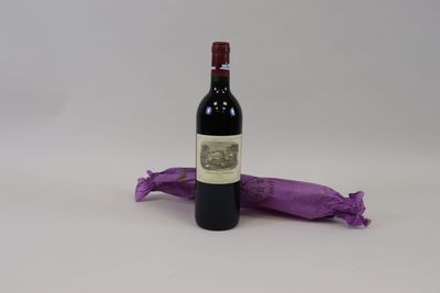 une bouteille de vin posée à côté d'un sac violet