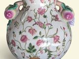 a white vase with pink flowers on it on a white background