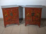 two red cabinets with oriental designs on them on a tiled floor