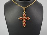 un collier en or avec un pendentif en forme de croix rouge sur un mannequin noir