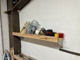 a wooden shelf with tools on it in a garage