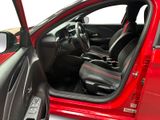 the interior of a red car with the door open and the driver ' s seat up