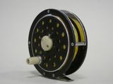 a close up of a fishing reel on a white surface