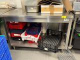 a metal table with baskets on it in a kitchen
