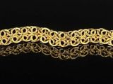 an image of a gold plated bracelet on a black surface