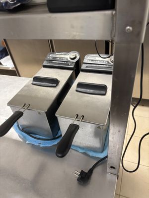 deux friteuses posées sur un plan de travail dans une cuisine