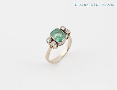 a close up of a ring with a green stone on it