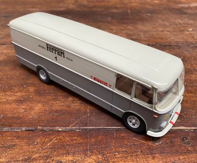 un petit bus en jouet posé sur une table en bois