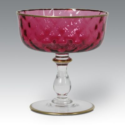 pink glass goblet with gold rim on a white background