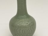 a green vase with a design on it on a white surface