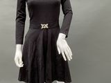 an image of a mannequin wearing a black dress with a gold belt